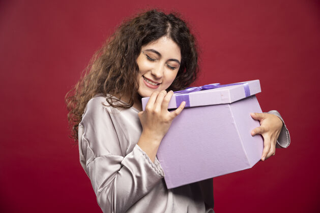 生日手持紫色礼盒的年轻女子肖像礼物冬天