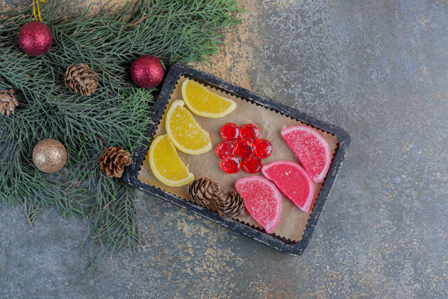 甜点甜甜的果酱和圣诞松果放在深色盘子里高质量的照片美食糖果糖果