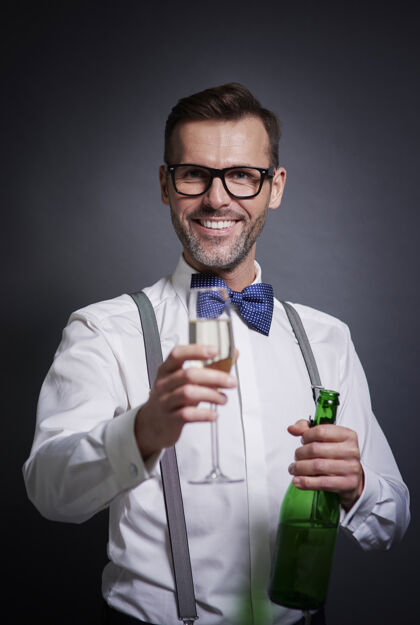 饮料优雅的男人拿着一瓶香槟和香槟笛年份聚会微笑