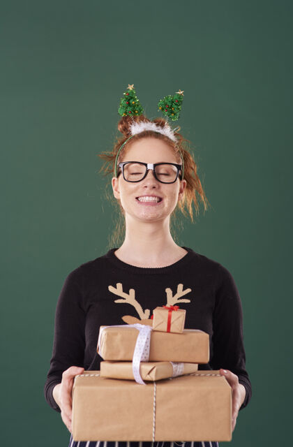 微笑快乐的女孩拿着一堆圣诞礼物庆祝制造一个脸开朗