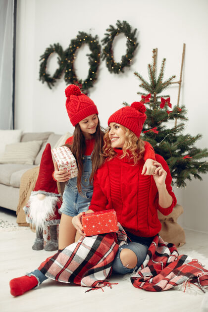 孩子人们在为圣诞节做准备母亲在和女儿玩耍一家人在节日的房间里休息孩子穿着红色毛衣花环给小