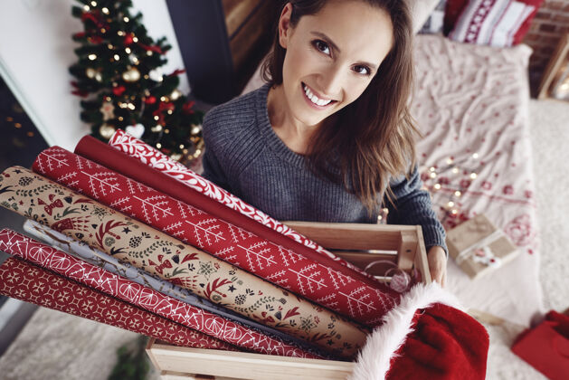 准备一个拿着圣诞纸的木箱的女人时间节日圣诞纸
