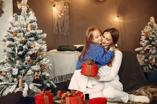 花环人们在为圣诞节做准备母亲在和女儿玩耍一家人在节日的房间里休息孩子穿着蓝色毛衣女人发光节日