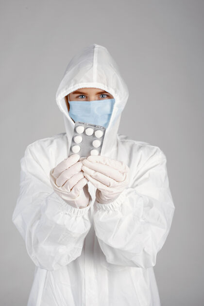 从业者戴着医用面罩的医生冠状病毒主题隔离在白墙上带着药片的女人医生肖像药丸