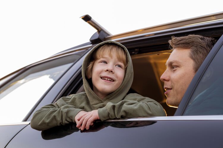 孩子低角度的父子俩在车上公路旅行远足男人休闲
