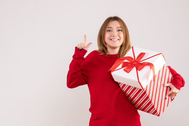 成人正面图年轻女性手拿礼物盒站着手圣诞节盒子