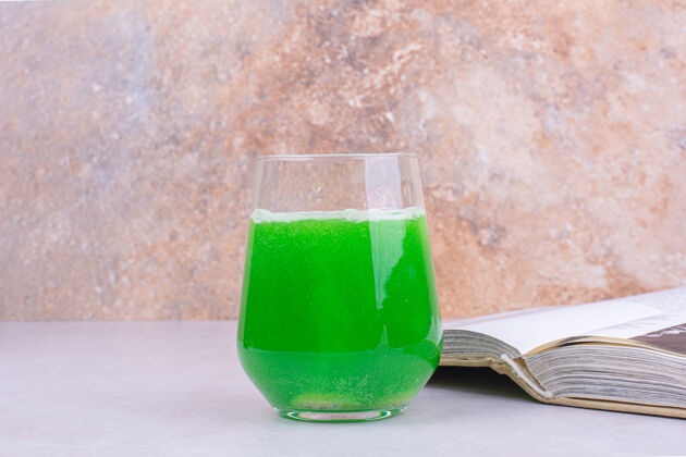 鸡尾酒一杯绿色鸡尾酒放在白色的桌子上未来派饮料冷