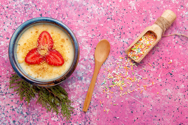 奶油顶视图美味的奶油甜点与淡粉色背景上的红色切片草莓甜点冰淇淋甜浆果午餐勺子水果
