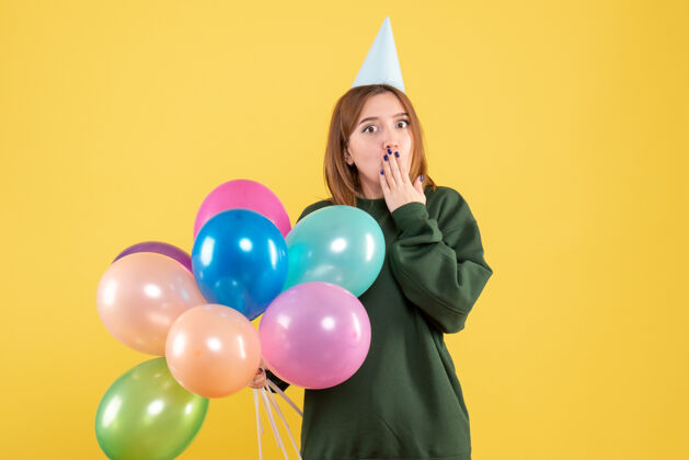 生日正面图：带着彩色气球的年轻女性圣诞节庆祝乐趣