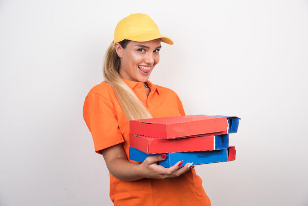 食物带着黄色帽子的送货员拿着白色背景的披萨盒手势用餐人