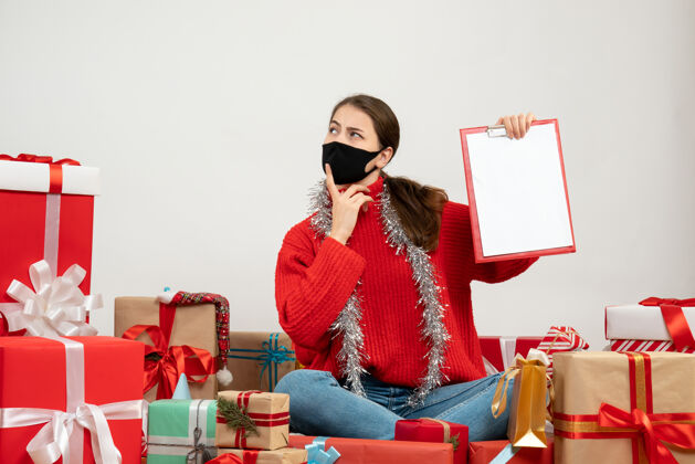 成人带着黑色面具的体贴女孩拿着文件围坐在白色的礼物上文件礼物礼物