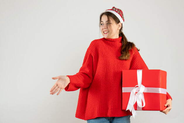 人戴着圣诞帽的快乐女孩在白色衣服上送礼物快乐的女孩工作圣诞老人