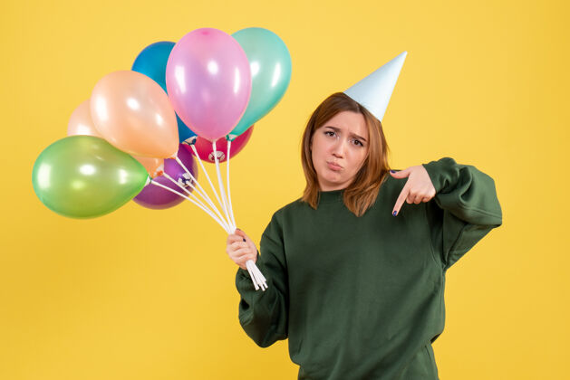 吹正面图：带着彩色气球的年轻女性生日气球五颜六色