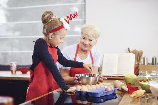 厨房奶奶和女孩在厨房里烤面包圣诞节帮手帮助