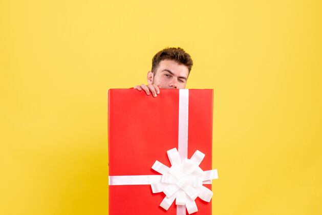 雪正面图年轻男子藏在礼品盒内颜色圣诞老人里面