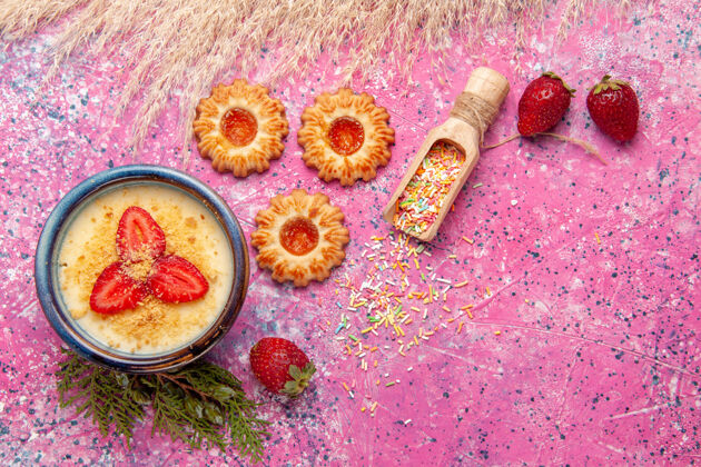 浅粉色俯瞰美味的奶油甜点与红色切片草莓和饼干淡粉色桌面甜点冰淇淋甜浆果草莓颜色新鲜
