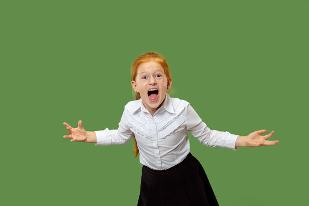 愤怒在绿色摄影棚背景下 年轻的愤怒少女尖叫着手势有吸引力年轻