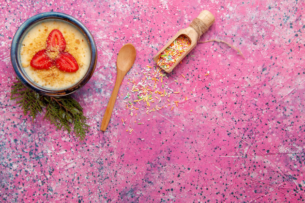 切片的俯瞰美味的奶油甜点 淡粉色背景上有红色草莓片甜点冰淇淋甜浆果甜点晚餐肉