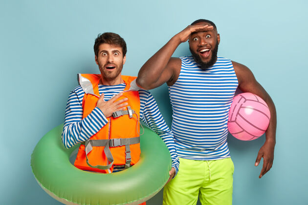 在一起喜出望外的年轻人身着水手t恤和短裤 手持沙滩球游泳非洲水手