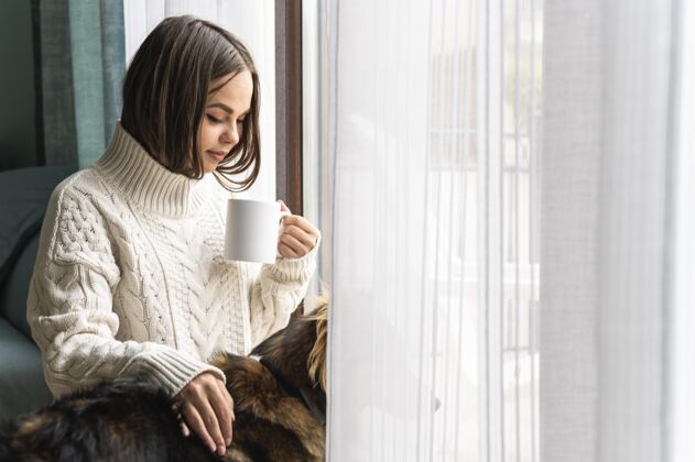 女人大流行期间 家里靠窗喝咖啡的女人家距离预防