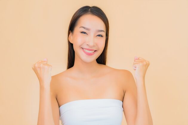 年轻肖像美丽的年轻亚洲女子在温泉与自然化妆米色时尚女性可爱