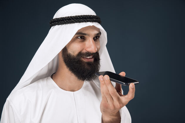 衣服深蓝色工作室背景的阿拉伯沙特男人惊讶表情伊斯兰教