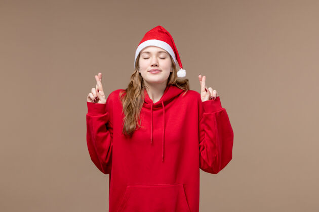 快乐前视图圣诞节女孩交叉她的棕色背景模型圣诞节手指人模型前面