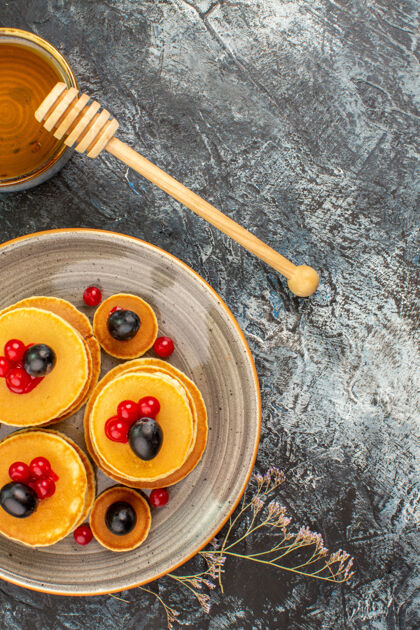 柱塞美味的水果煎饼和蜂蜜的垂直视图卷轴工具蜂蜜