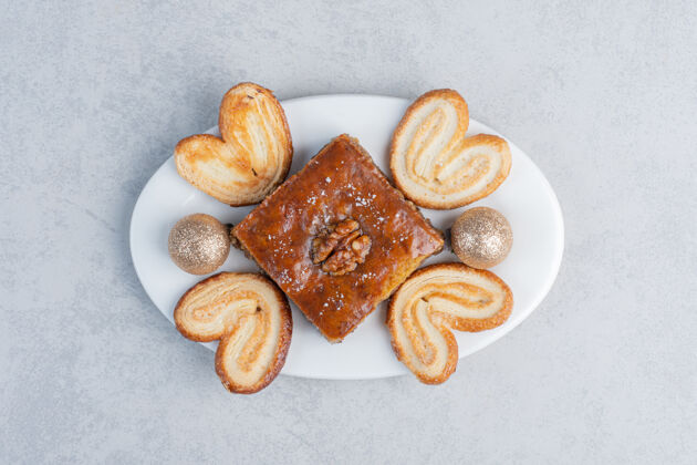 甜点薄饼和烤面包放在盘子上 大理石表面有装饰物糖果美味片状