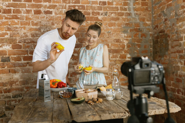 博客年轻夫妇烹饪和录制视频直播的虚拟博客和社交媒体视频烹饪博客