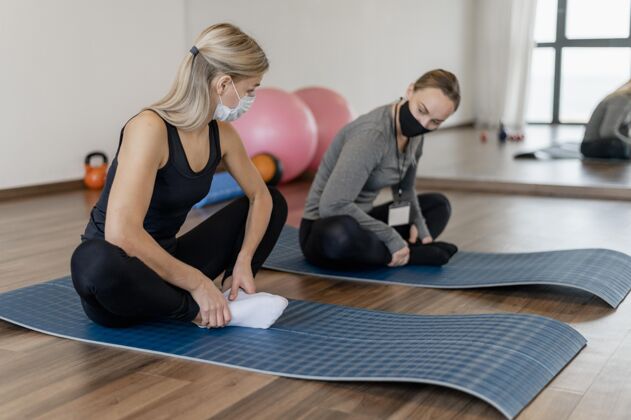 女人年轻女子在健身房锻炼 并在瑜伽垫上指导健身锻炼健康