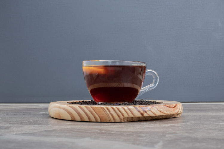 红茶放在大理石桌上的木盘上的热茶木制饮料杯子