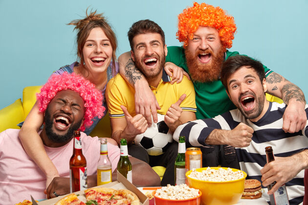 比赛镜头中友好的同伴们开心地拥抱和微笑 与获胜的最爱球队一起加油 一起看精彩的足球赛 喝啤酒 吃快餐 开心的球迷们支持瓶子尖叫啤酒