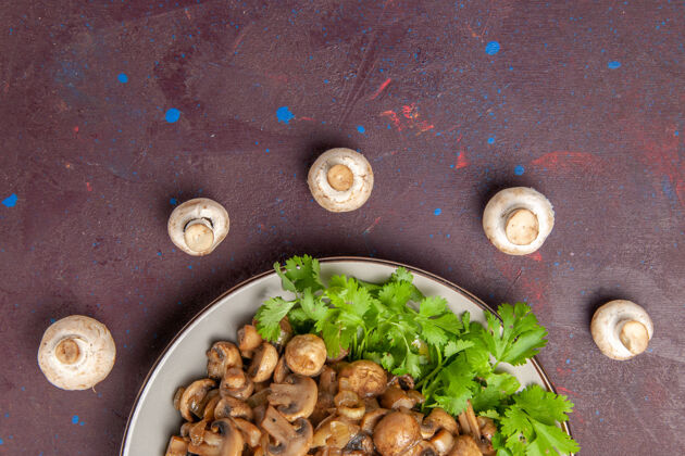 盘子在黑暗中俯瞰美味的蘑菇和绿色蔬菜晚餐菜植物