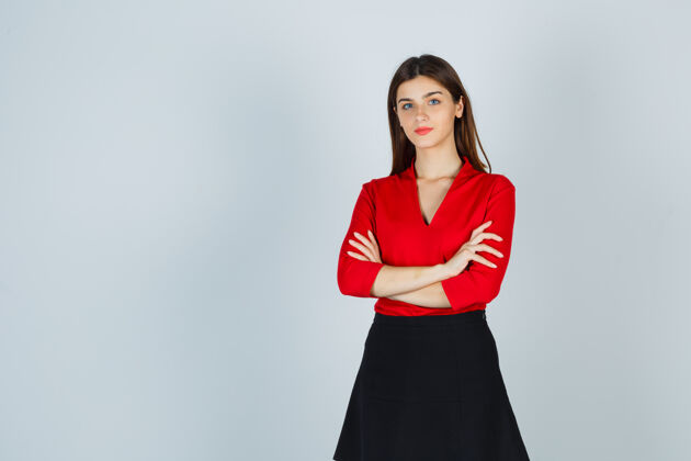 专业年轻的女士交叉着双臂站着 穿着红色上衣 黑色裙子 看上去很自信女士交叉电脑