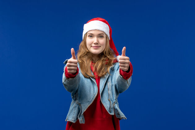人物正面图年轻女性在蓝色背景上微笑圣诞情感色彩微笑女性时尚