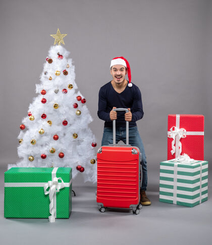 灰色快乐的年轻人 灰色的红色手提箱圣诞树数字快乐