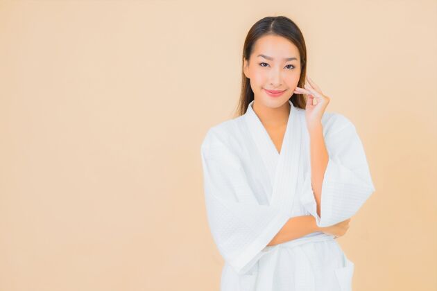 淋浴肖像美丽的亚洲年轻女子穿着米色的微笑浴袍时尚模特护理