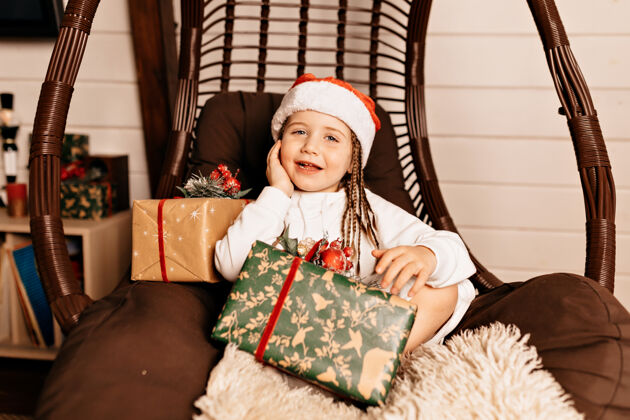 礼物有圣诞礼物的快乐女孩椅子盒子节日