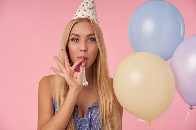 发型年轻快乐的金发女郎用五颜六色的气球庆祝生日 吹派对号角 对着镜头真诚微笑人 娱乐和节日属性长发休闲20多岁