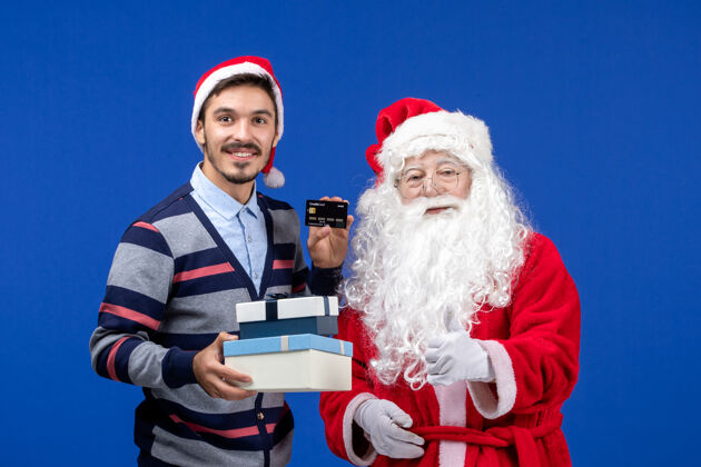 礼物正面图：圣诞老人和手持礼物的年轻男性举行年轻情感