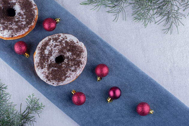糕点在白色背景的折叠桌布上 由美味的甜甜圈和圣诞装饰品组成圣诞烘焙圣诞树