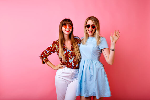 魅力两个快乐美丽的姐妹最好的朋友时髦的女人在粉红色的工作室背景一起玩姐妹背景拥抱