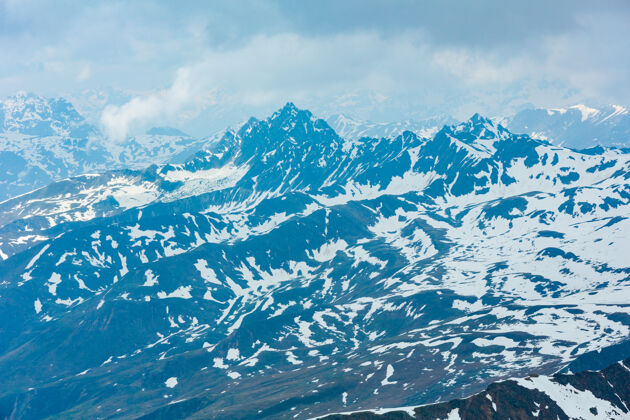 山峰六月从卡尔斯乔克阿尔卑斯山（3108米 靠近奥-意边界的考恩塔尔-格雷彻）俯瞰悬崖和云层山岩石季节