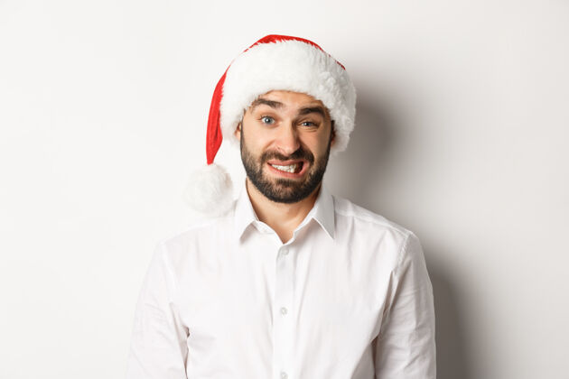 商人戴着圣诞帽的尴尬家伙道歉 感觉不舒服 站在圣诞概念的特写镜头胡须聚会快乐