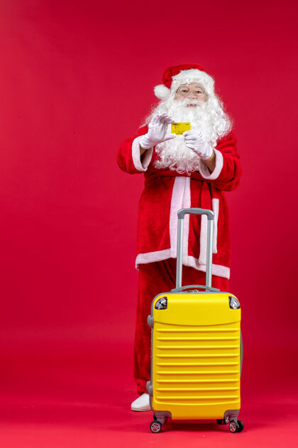 快乐红墙上拿着黄色银行卡的黄色袋子的圣诞老人的正视图庆祝圣诞老人银行