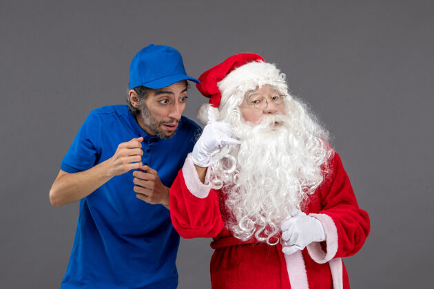 冬天灰色墙上的圣诞老人和男信使的正面图圣诞圣诞快乐节日