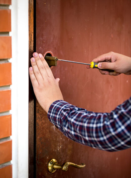 螺丝刀木匠用螺丝刀固定门锁的特写镜头木工建筑工人设备