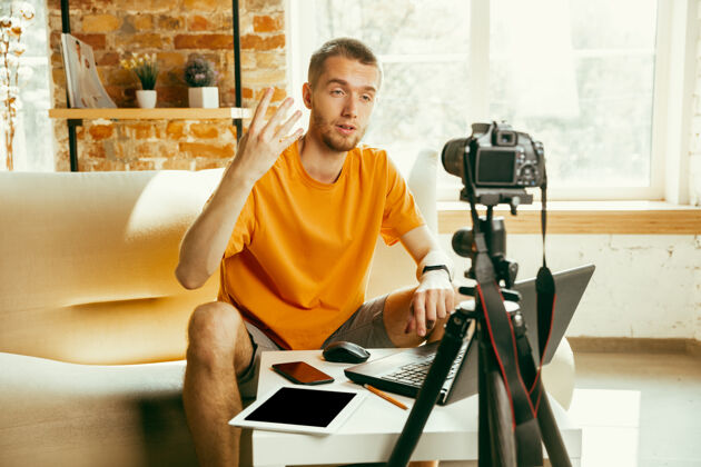 大众年轻的白人男性博主 带着专业的摄像机 对家里的小玩意进行视频评论博客 视频博客 视频博客关于照片或技术新颖性的男人制作视频博客或直播流互联网男性视频