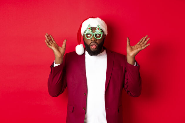 开朗圣诞快乐快乐的黑人戴着滑稽的聚会眼镜和圣诞帽庆祝时尚胡须